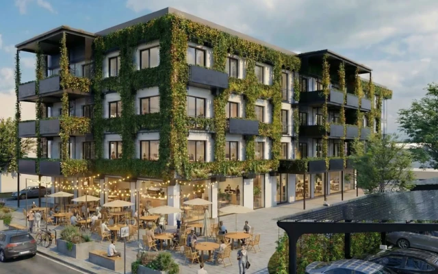 Gebäude mit Grünzeug an der Fassade vor dem viele Menschen sitzen