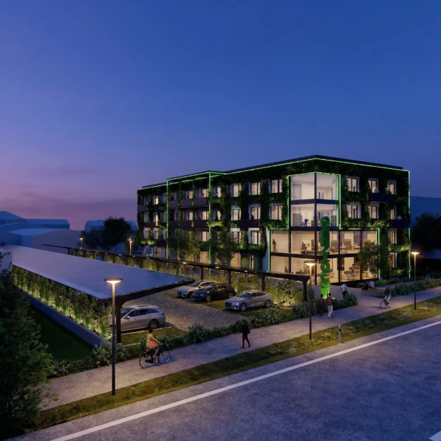 Das Greenhouse abends mit grüner Beleuchtung am Gebäude